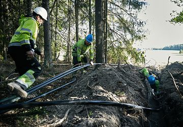 Cable workers installing Axal-TT medium voltage cable in rough terrain